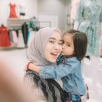 an asian malay young woman shopping in a boutique shop with her daughter