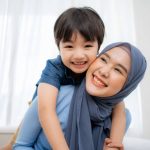 Mother and son spend time together and hugging gives a tulip flower on mothers day together at home.